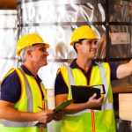 Young man receiving on-the-job training in a construction setting from older man