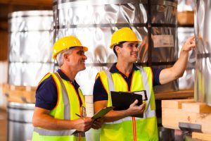 Young man receiving on-the-job training in a construction setting from older man