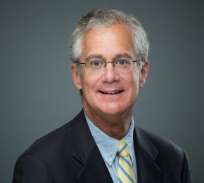 Middle aged man with gray hair and glasses is smiling