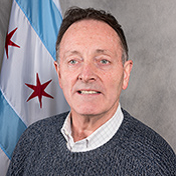 Middle aged man with short dark hair smiles at camera