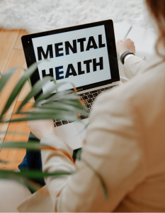 An open laptop with words Mental Health displayed on the screen.